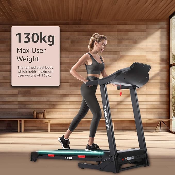 Persona caminando sobre la cinta de correr en casa, con indicación de 130 kg de peso máximo de usuario